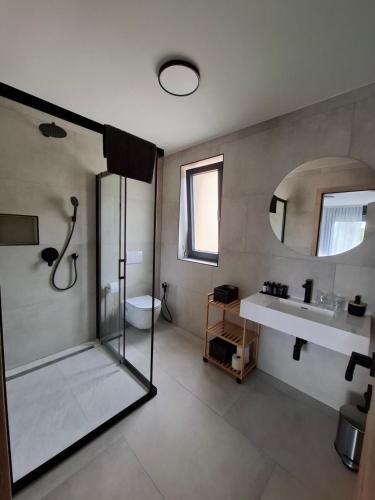 a bathroom with a shower and a sink and a mirror at Paradiso Beach House in Lopar