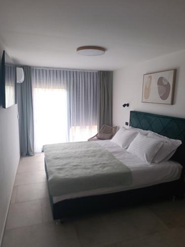 a bedroom with a large bed and a window at Paradiso Beach House in Lopar
