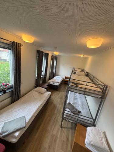 a room with two bunk beds and a window at Brålanda Hotell och Vandrarhem in Brålanda