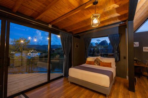 a bedroom with a bed and a large window at GRETEL CHALETS SUIZO in Guatapé