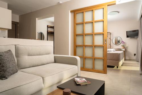 a living room with a couch and a table at Alpha Waves By Banana Beach in Vasilikos