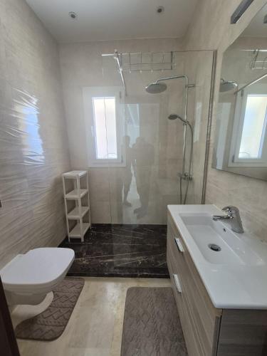 a bathroom with a toilet and a sink and a shower at Villa mnar 3 chambre en haut in Tangier