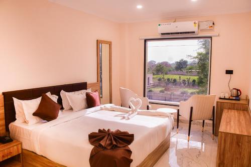 a bedroom with a large bed with a large window at Mandu's Green Valley Resort in Māndu