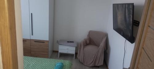 a room with a chair and a desk and a television at Twins Residence 2 APART HOTEL AP 2 2 rooms in Chiajna