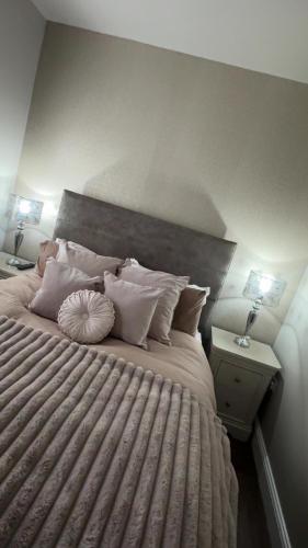 a bedroom with a large bed with pillows at 18 Garden Mews in Cookstown