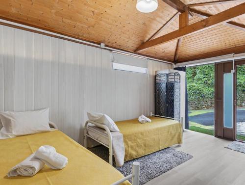 a bedroom with two beds and a table and a chair at Casa da Moleira in Amares