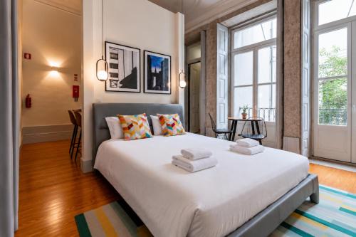 a bedroom with a large white bed with towels on it at Mouzinho 226 in Porto