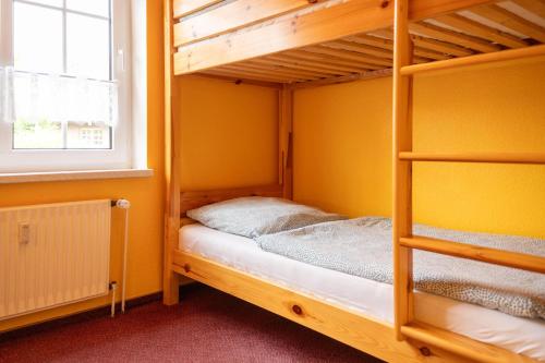 a bunk bed in a room with yellow walls at Ferienwohnung Hoffmann in Hooksiel