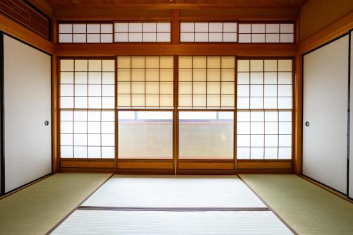 una habitación vacía con puertas y ventanas en KOAのお宿 ー Koa no Oyado ー, en Gujō
