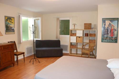 a bedroom with a bed and a chair and a desk at La Bastide des Marcassins in Moissac-Bellevue