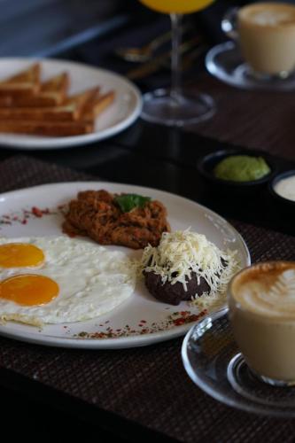 a plate with a fried egg on a table with french fries at Hotel Jirahara in Barquisimito