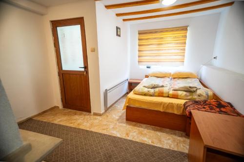 a bedroom with a bed and a window and a door at Кампинг Петлето in Sokolovtsi