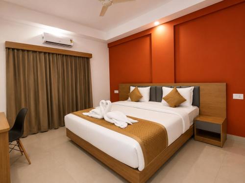 a hotel room with a bed with a towel on it at Nova Alhind Airport Hotel Cochin in Nedumbassery