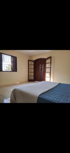 a bedroom with a large bed and two windows at Chácara com piscina no condomínio Vitassay in Boituva