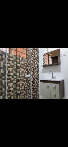 a bathroom with a sink and a counter and a mirror at Chácara com piscina no condomínio Vitassay in Boituva