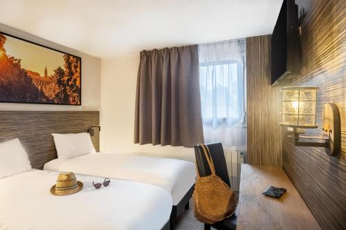 a hotel room with two beds and a window at Sure Hotel by Best Western Angers Sud in Les Ponts-de-Cé
