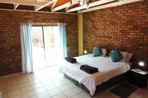 a bedroom with a large bed in a brick wall at Hide Away Wedding,Conference & Function Venue in Bela-Bela