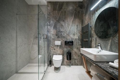 a bathroom with a sink and a toilet and a shower at Termalne Spanie w Chochołowskich Termach in Chochołów