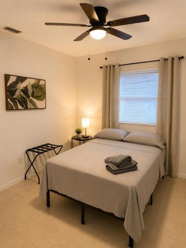 a bedroom with a bed with a ceiling fan at Fauna Beach in Gold Coast Heliport