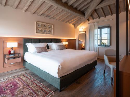 a bedroom with a large white bed and a window at Tenuta Bartoli in San Gimignano