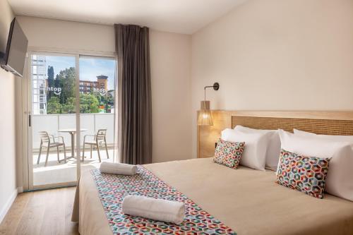 a bedroom with a bed with a view of a balcony at htop Amatista - Bliss in Lloret de Mar
