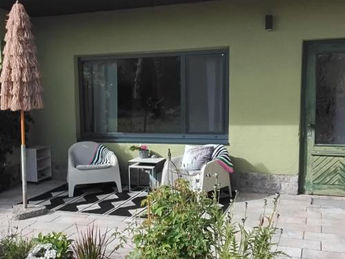 a patio with two chairs and a window at Ferienbungalow Haus Rolf _ Objekt in Papendorf