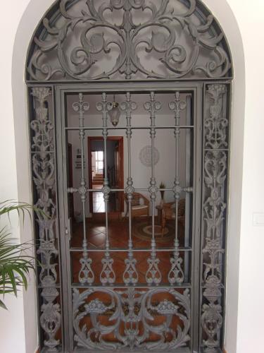 an ornate metal door in a room with a table at Casa Rural El Pergareo in Cazalla de la Sierra