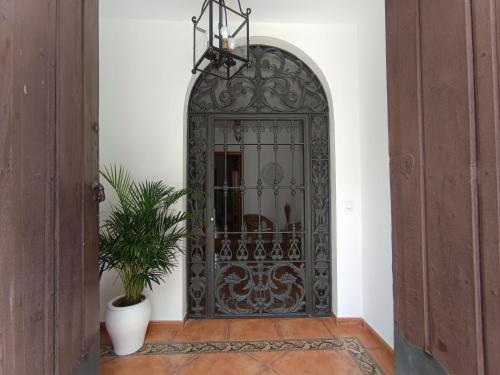 an iron door in a hallway with a plant at Casa Rural El Pergareo in Cazalla de la Sierra