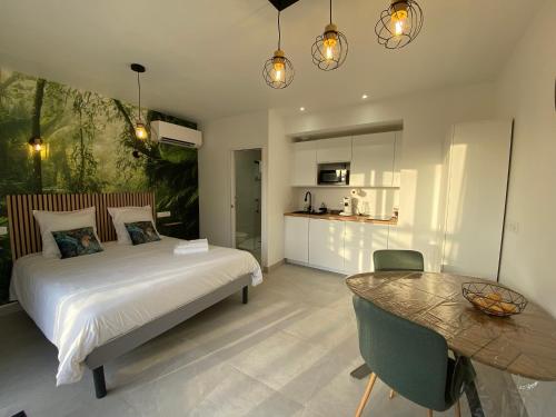 a bedroom with a bed and a table in it at La Maison Blanche 1 in Bouguenais