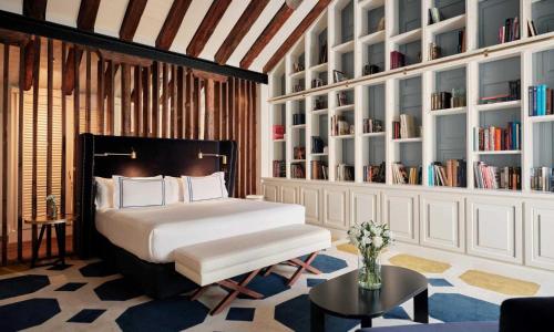 a bedroom with a bed and a table and bookshelves at Only YOU Boutique Hotel Madrid in Madrid