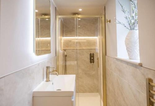 a bathroom with a sink and a shower at The Annexe in Cobham