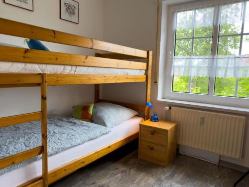 a bedroom with two bunk beds and a window at Nordseeperle in Wangerland