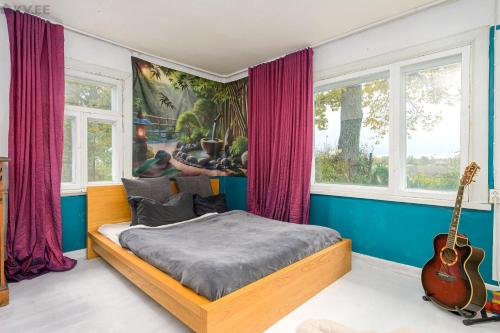 a bedroom with a bed and a guitar at Zen Garden House in Võduvere