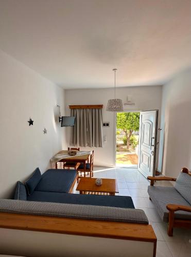 a living room with a blue couch and a table at EFFIE'S STUDIOS in Alinda