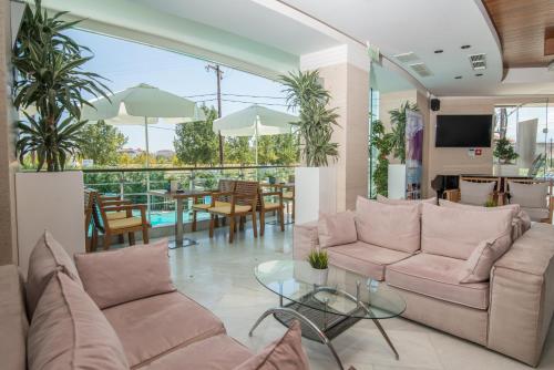 a living room with a couch and a table at Cosmopolitan Hotel in Paralia Katerinis