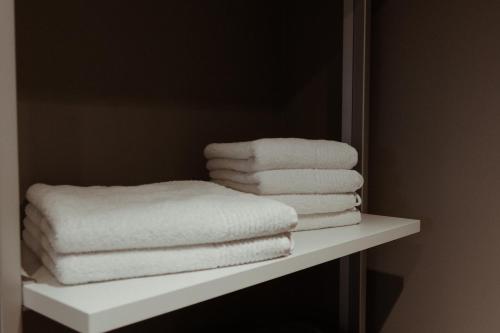 a pile of towels on a shelf in a bathroom at Schlossberghotel Greiz in Greiz