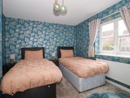 a bedroom with two beds and a window at 18 Hengrave Meadow in Telford
