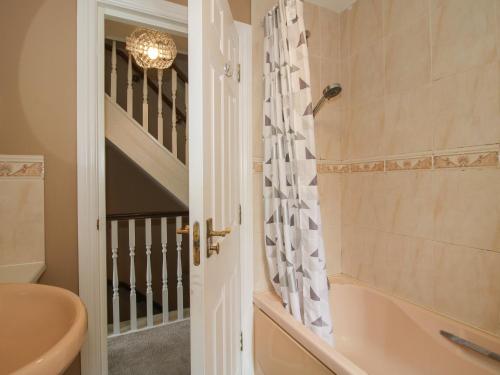 a bathroom with a tub and a toilet and a sink at 18 Hengrave Meadow in Telford