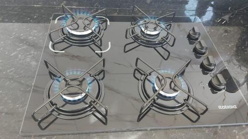 a set of four burners on a glass table at Lar Tranquilo Com Garagem in Pirassununga