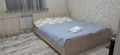 a small bedroom with a bed with towels on it at AiDan BB in Kazarman