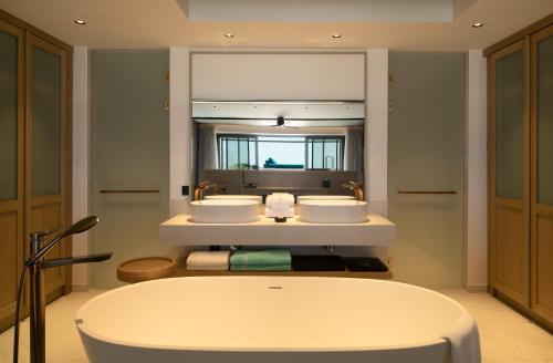 a bathroom with two sinks and a large mirror at Mitsis Summer Palace in Kardamaina