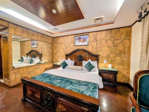 a bedroom with a large bed and a mirror at Hotel Galaxy in Karachi