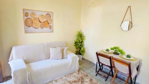 a living room with a white couch and a table at Sao Luis Praia Studio in São Luís