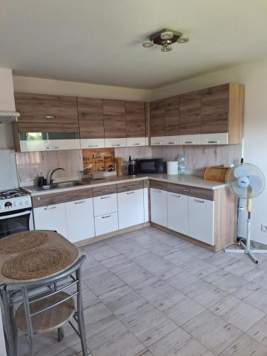 a kitchen with white cabinets and a table in it at Apartament Alicja in Chmielno
