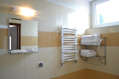 a bathroom with a shower with a mirror and towels at Noclegi Sezam in Łańcut