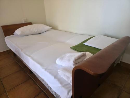 a bed with white sheets and towels on it at Alkyon Villas in Syvota