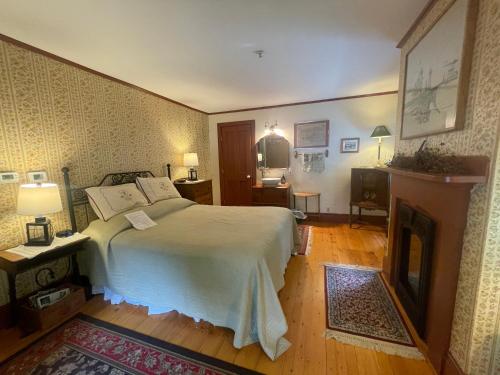 a bedroom with a large bed and a fireplace at Black Lantern B&B in Topsham