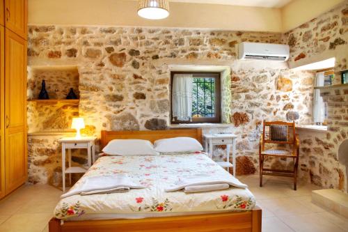 a bedroom with a bed and a stone wall at Villa Limon by Important Group Travel in Bitez