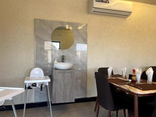 a dining room with a sink and a table with chairs at Ravens nests lodge in Livingstone