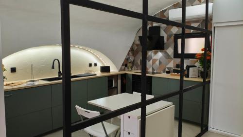 a kitchen with green cabinets and a white table at Mirador in Beja